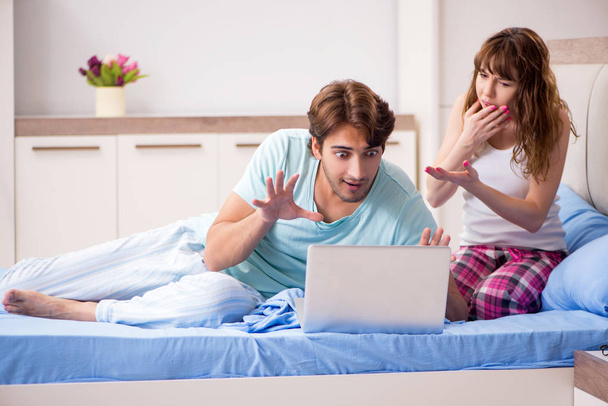 junges Paar mit Laptop im Schlafzimmer  - Foto, Bild