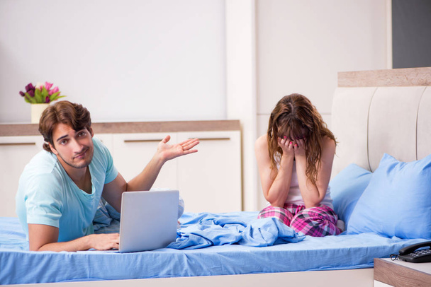 Giovane coppia con computer portatile in camera da letto
  - Foto, immagini