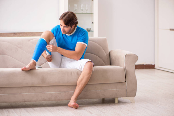 Noga ranny młody człowiek na kanapie - Zdjęcie, obraz