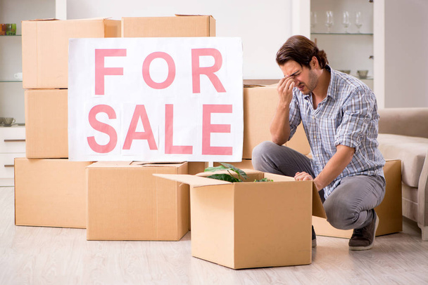 Jonge man home te koop aanbieden en verhuizen  - Foto, afbeelding