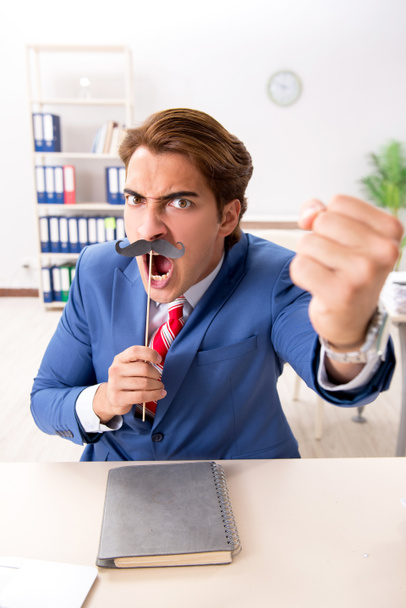 Забавный бизнесмен с фальшивыми усами в офисе
 - Фото, изображение