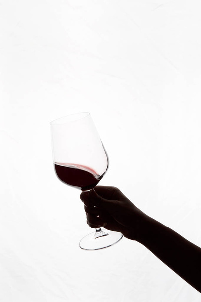 mano che tiene un bicchiere di vino rosso - Foto, immagini