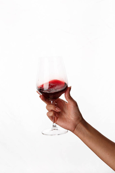 χέρι κρατώντας ένα ποτήρι κόκκινο κρασί - Φωτογραφία, εικόνα