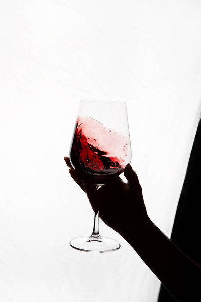 рука держит бокал красного вина - Фото, изображение