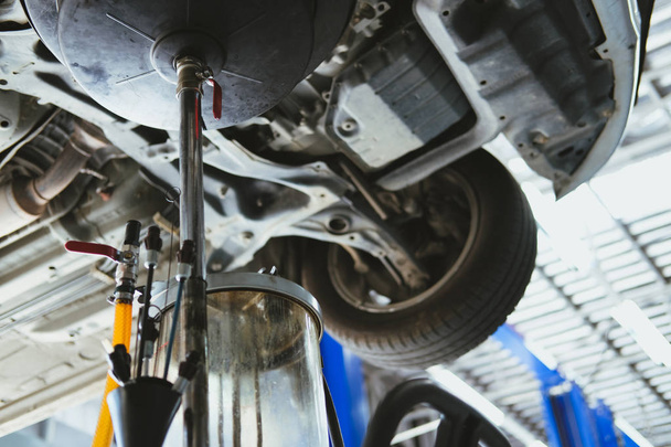 jármű Emeld fel a hidraulikus motor olaj-módosítás és továbbítása ellenőrzési. változó motorolaj autó javítási szolgáltatást. karbantartás és szűrés a autó-workshop. - Fotó, kép