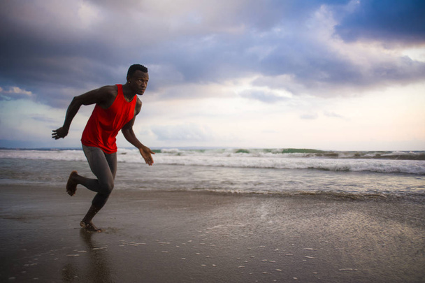 young attractive fit athletic and strong black African American man running at the beach training hard and sprinting on sea water in professional athlete lifestyle and ripped runner workout  - Φωτογραφία, εικόνα