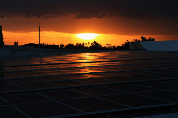 Сонячна Pv на даху з захід сонця фоном червоне небо - Фото, зображення