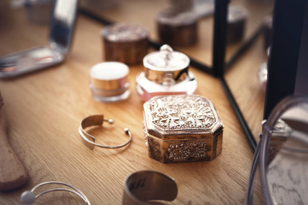 una caja de plata de accesorios vintage poner en un tocador con pulseras y algunos cosméticos
 - Foto, imagen
