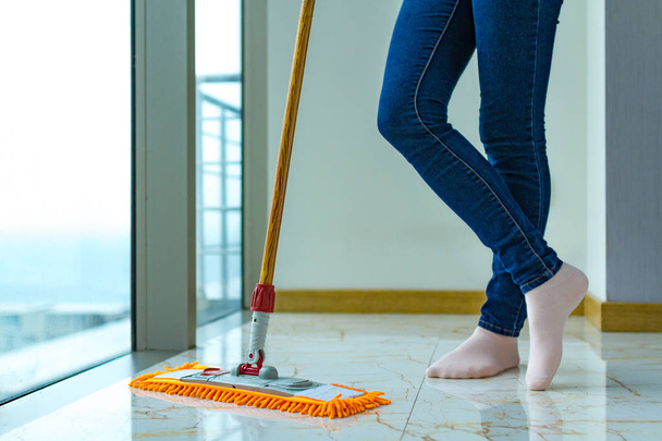 La ama de casa está limpiando la casa, limpiando el piso. Trabajo doméstico, tareas domésticas. Lavado de suelos
 - Foto, imagen