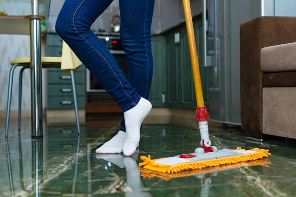 Домохозяйка занимается уборкой дома, уборкой. Уборка дома, мытье полов. Домашние дела
 - Фото, изображение