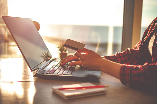 Online winkelen en online betaling voor aankopen, goederen per creditcard met het gebruik van een laptop. Bestelling goederen online - Foto, afbeelding