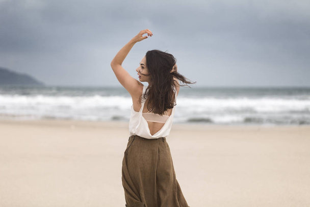 Lifestyle portrait of happy carefree woman walking on the beach with space for text. - Foto, Imagem