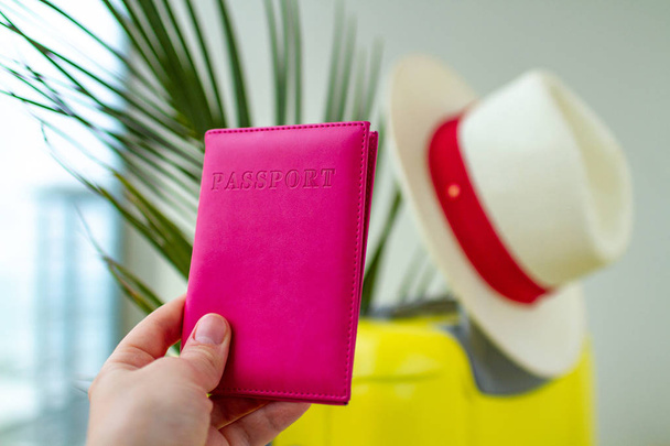 Yellow suitcase, hat, tourist passport, palm branch. Vacation planning - 写真・画像