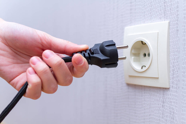 Ready to connect. Plugging electrical, black plug in electric socket on wall.  - Foto, Imagem