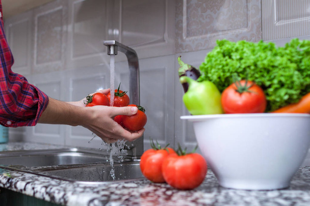 Woman washing vegetables in the kitchen. Vegetables for cooking salad. Right and healthy food, proper nutrition.  - Photo, Image