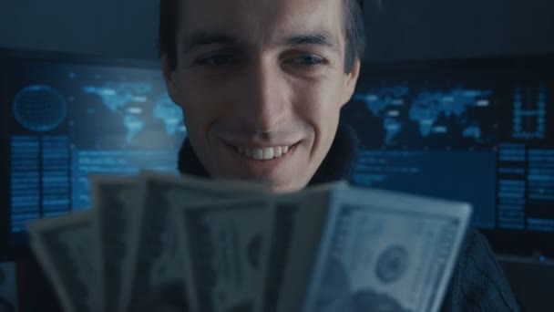 Portret van Hacker programmeur telt geld verdiend ith strafrechtelijk op Darknet in cyber Beveiligingscentrum gevuld met schermen. - Video