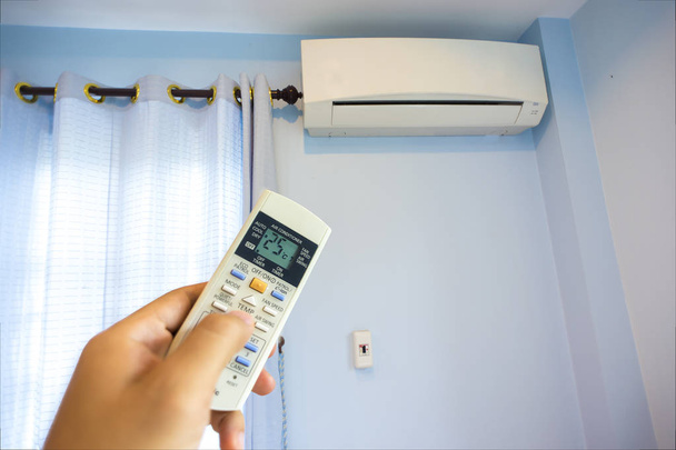 Ręka Włączanie domu klimatyzacja o 25 stopni, oszczędność energii - Zdjęcie, obraz