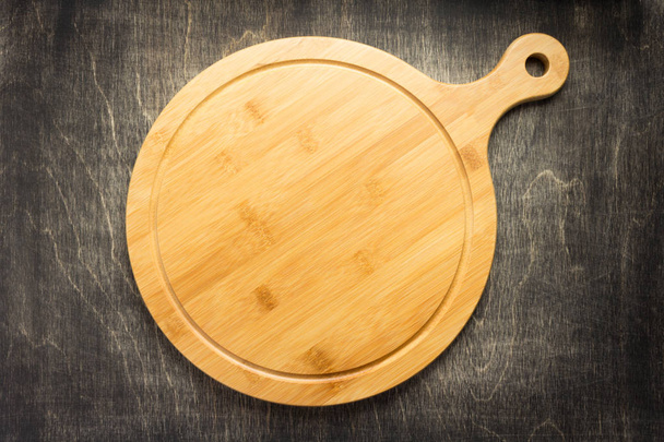 cutting board at old wooden table, top view - Foto, afbeelding