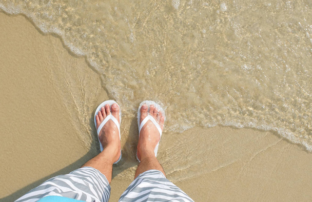 Sandales flipflop blanc sur la plage de la mer
 - Photo, image