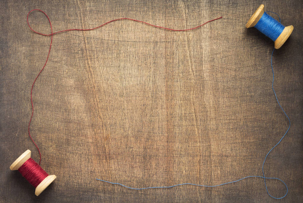 sewing thread on wooden table background, top view - 写真・画像