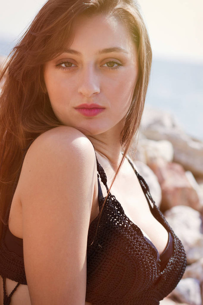 Attractive young brunette in swimsuit posing at the seaside in Greece - 写真・画像