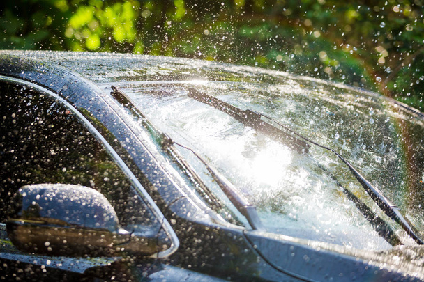 Ветровое стекло автомобиля с капельками дождя и лезвием стеклоочистителя
 - Фото, изображение