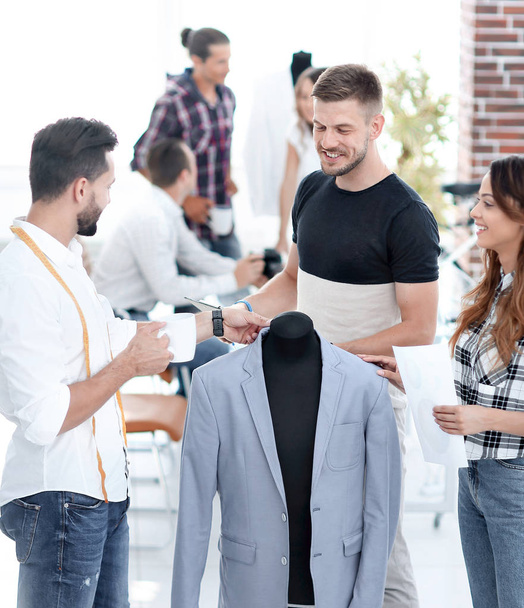 group of designers discuss mens suit - Foto, afbeelding