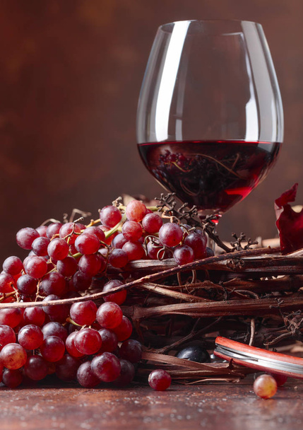 Червоне вино і свіжий виноград з висушеним листям лози, скопіюйте місце для тексту
. - Фото, зображення