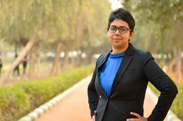 Jovem mulher indiana trabalhando profissional de negócios posando com as mãos na cintura em um terno corporativo formal em um local ao ar livre
 - Foto, Imagem