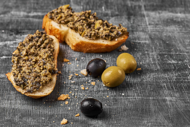 Bruschetta with green olives, anchovies,capers, selective focus, low angle view. close-up - Foto, Bild
