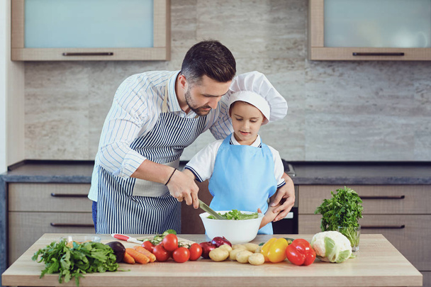 Father and son are cooking in the kitchen - Fotoğraf, Görsel
