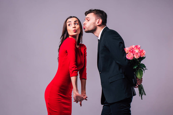 Love you so much! Beautiful stylish and elegant couple in suit and dress are hugging, have a fun and posing isolated in studio. Holidays and events. St Valentine's day. Day of lovers - Foto, Bild