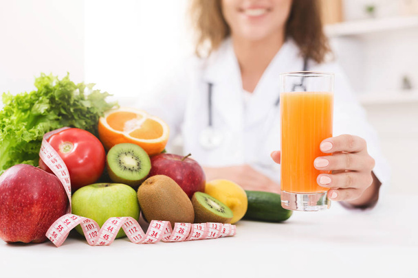Διατροφολόγος που προωθούν την υγιεινή διατροφή, προσφέροντας χυμό πορτοκαλιού - Φωτογραφία, εικόνα