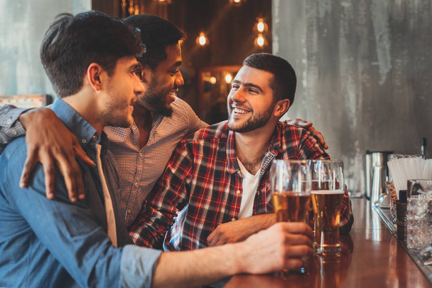 Old friends drinking beer and talking in pub - Fotoğraf, Görsel