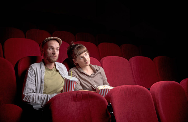 Young couple sitting at red movie theatre - Foto, imagen