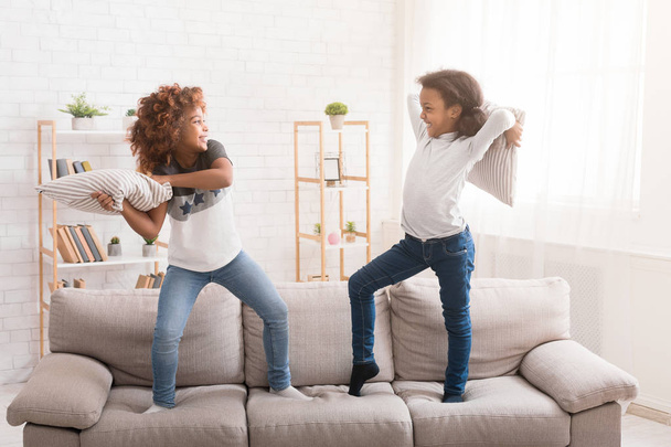 Little friends fighting with pillows, having fun together - Photo, Image