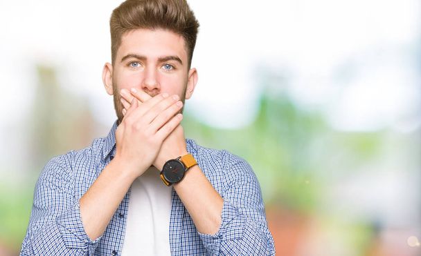Young handsome blond man wearing casual shirt shocked covering mouth with hands for mistake. Secret concept. - Fotoğraf, Görsel