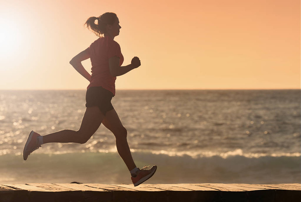 Woman running on beach in morning sunrise, fitness workout sport - Foto, afbeelding