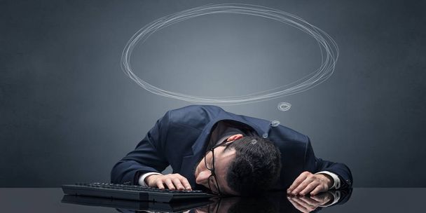 Businessman sleeping and dreaming at his workplace - Фото, изображение