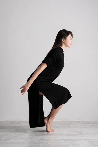 Sporty young woman doing yoga practice on white background - concept of healthy life and natural balance between body and mental development. - Φωτογραφία, εικόνα