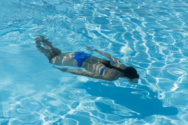 Kadın bir mavi su üzerinde yüzme mayo ile. Sualtı kadın portre yüzme havuzunda mavi bikini ile. - Fotoğraf, Görsel