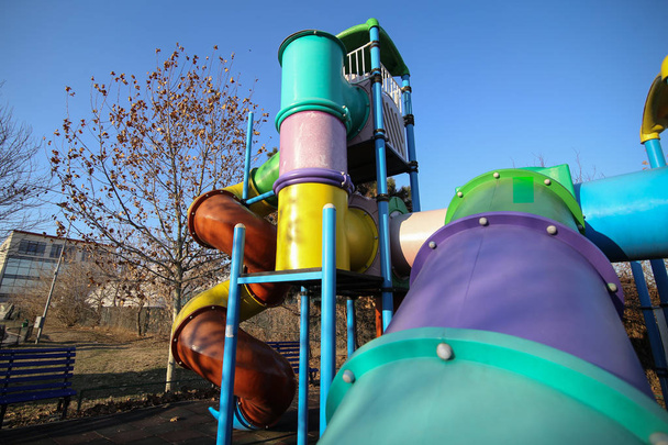Colorful kids playground in a park during winter, with plastic slides and other items - Photo, Image