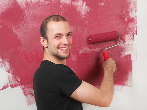Homem alegre pintando a parede
 - Foto, Imagem