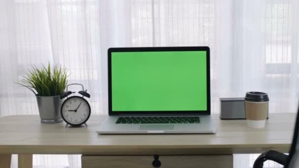 Pantalla verde 4K de la computadora portátil fijada en el espacio de trabajo en la oficina acogedora, tiro del zoom hacia fuera
 - Metraje, vídeo