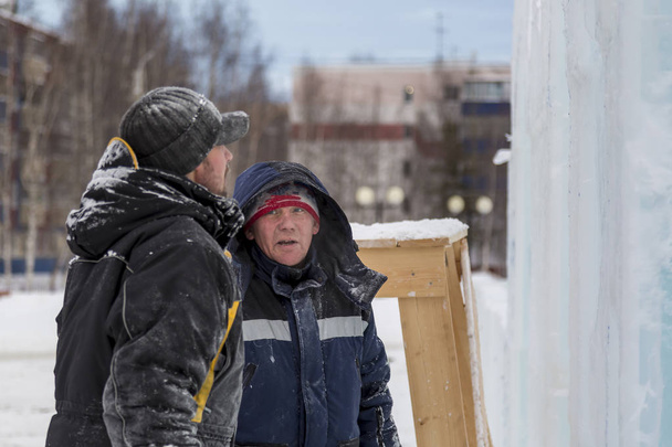 Trabajadores en el sitio de construcción de la ciudad de hielo para una conversación
 - Foto, imagen
