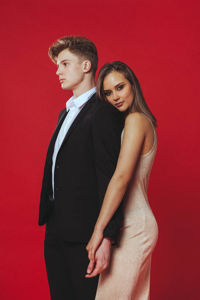 Beautiful young couple, on a red background. Young actors - Photo, Image