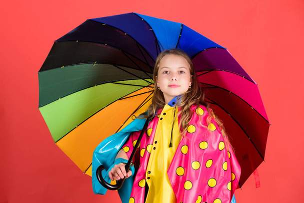 Waterproof accessories make rainy day cheerful and pleasant. Kid girl happy hold colorful umbrella wear waterproof cloak. Enjoy rainy weather with proper garments. Waterproof accessories manufacture - Foto, Imagen