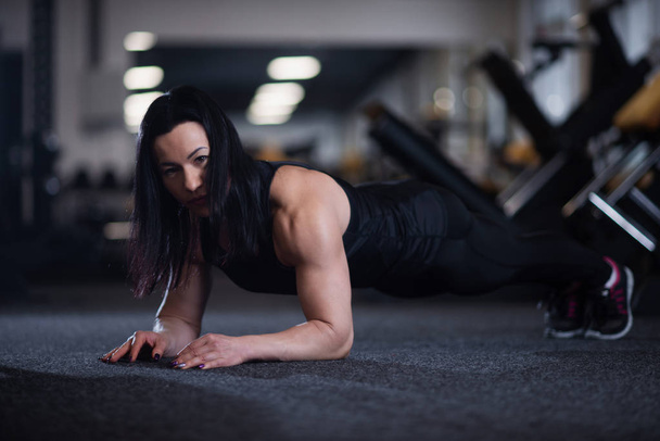 Young athletic woman doing push-ups in the gym. Woman doing yoga - Fotoğraf, Görsel
