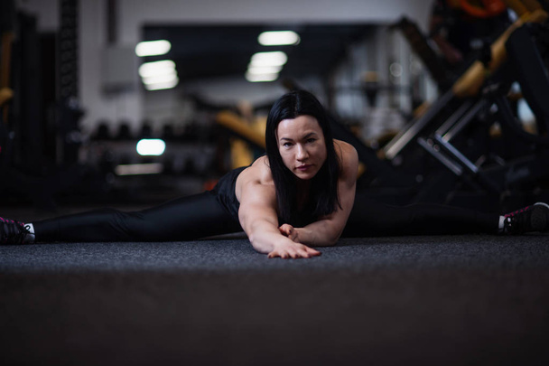 Young athletic woman doing splits in the gym. Woman doing yoga - Fotó, kép