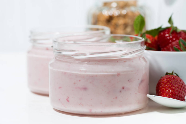 strawberry yogurt, granola and fresh berries on white background, closeup horizontal - Foto, afbeelding